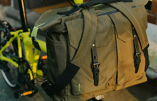 Ally Capellino X Brompton Frank Backpack attached to a green Brompton bike